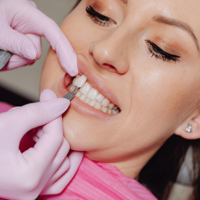 a woman getting her teeth checked, representing benefits of porcelain veneers