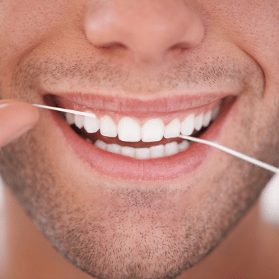 Person using floss on teeth, representing oral hygiene