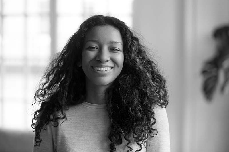 Fair Lakes Cosmetic Dentistry Happy Beautiful Woman Smiling young woman with beautiful smile and curly hair