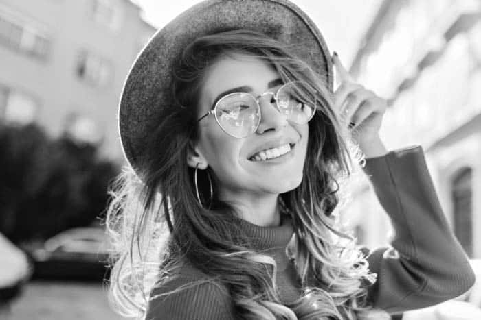 Fair Lakes Family Cosmetic Dentistry Happy Young Woman Glasses Outside Fair Lakes Family Cosmetic Dentistry Happy Young Woman Glasses Outside