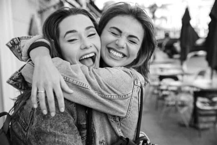 two woman hugging gleefully