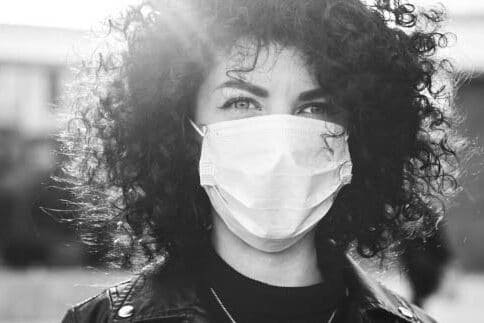 woman with short curly hair wearing mask covid policy