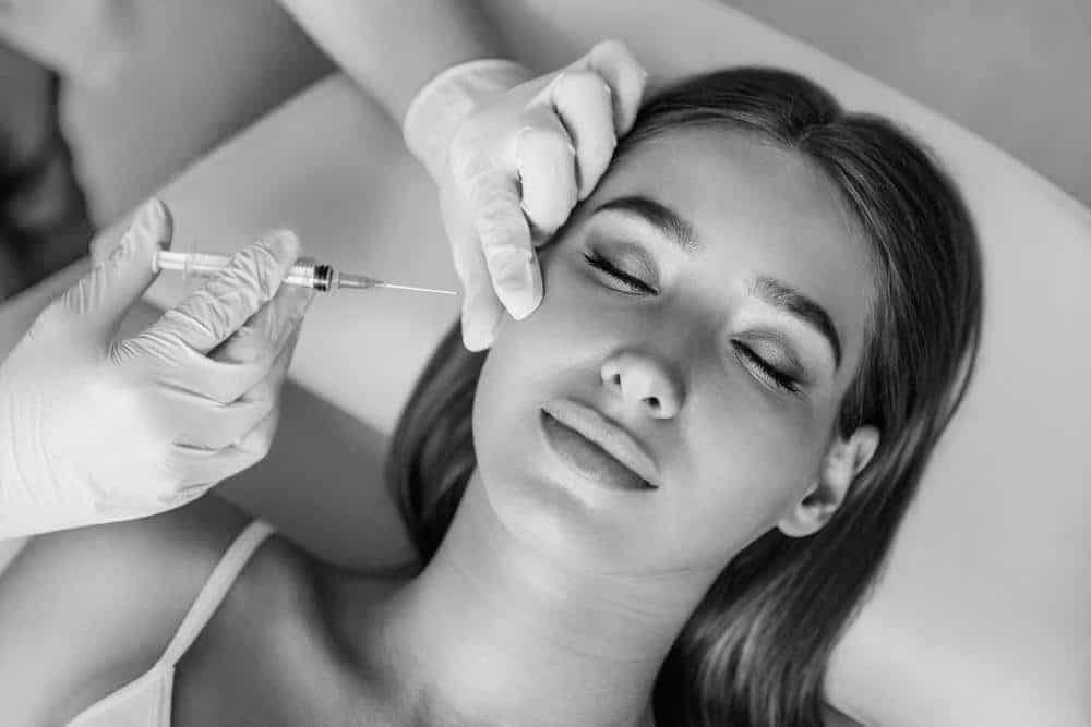 woman on medical chair receiving botox in face
