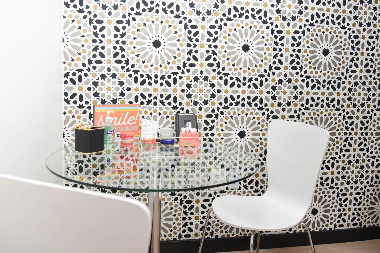 fair-lakes-cosmetic-dentistry-patterned-wall chair and desk in front of glass table and tile wall